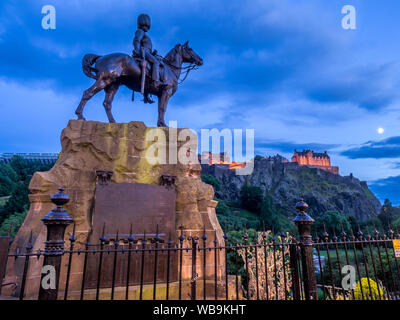 Royal Scots Greys Monument avec le Château d'Édimbourg à l'arrière-plan la nuit de Princes Street. Banque D'Images