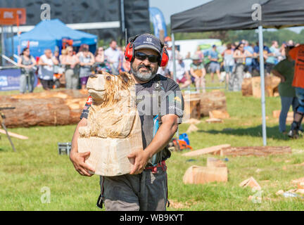 Knutsford, Cheshire, Royaume-Uni. 25 août 2019. La 15e English Open Chainsaw compétition à la Cheshire County Showground, Angleterre - Adrian Bois d'Argentine porte son supporter pour les gens de voir dans une vente aux enchères Crédit : John Hopkins/Alamy Live News Banque D'Images