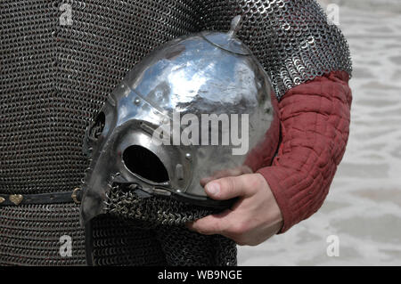 Casque de guerrier dans la main d'une personne vêtue de chain mail Banque D'Images