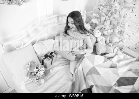 Petite fille se détendre à la maison. Noël famille vacances. bonne année. Les achats de Noël. petit enfant fille avec cadeau de Noël. Le matin avant Noël. Le Sommeil. en attente de santa. L'hiver. Regarder ça. Banque D'Images