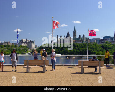 Les touristes et les drapeaux de l'admirez la vue sur la Colline du Parlement, du Musée de l'histoire (du côté québécois), Gatineau, Québec, Canada. Banque D'Images