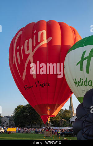 Strathaven, Ecosse, Royaume-Uni. Août 25, 2019. Montgolfières prépare à décoller avec le logo vierge et le Holiday Inn logo sur le côté, à l'Strathaven Montgolfières qui fête cette année son 20e anniversaire et est tenu à l'primé Strathaven Park.Le festival attire les pilotes et visiteurs de tous les coins de l'Europe avec plus de 25 000 spectateurs présents au cours de la fin de semaine. Credit : Skully/Alamy Live News Banque D'Images