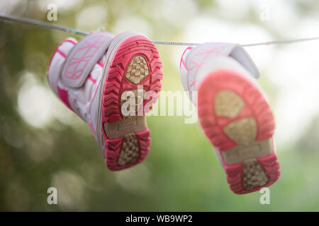 Chaussures sont séchées sur une corde dans un jardin d'été Banque D'Images