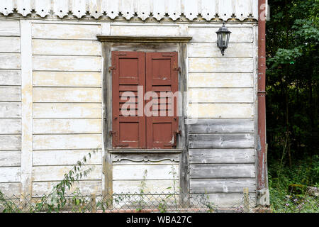 Vieille maison avec volets en bois fermé brun sur la fenêtre Banque D'Images