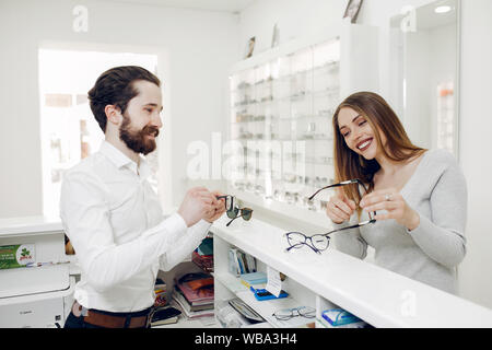 Mère avec mignon fils. Acheter des lunettes de la famille. Aider les clients Assistant Banque D'Images