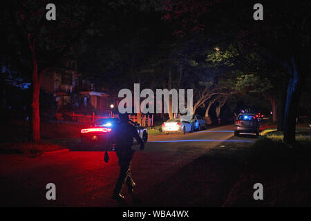 Véhicule d'opérations spéciales de la police de Detroit et officier dans la rue la nuit, Detroit, Michigan, USA Banque D'Images