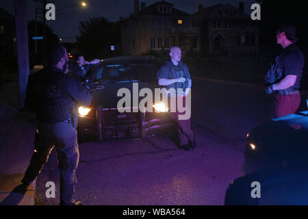 Opérations spéciales Detroit policiers parler par leur voiture à la nuit, Detroit, Michigan, USA Banque D'Images