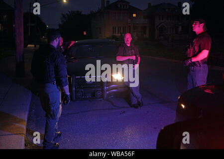 Opérations spéciales Detroit policiers parler par leur voiture à la nuit, Detroit, Michigan, USA Banque D'Images