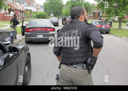 Service de police de Detroit, officier des opérations spéciales tiroirs son arme alors qu'il se prépare à aborder une maison, qu'ils en ont l'air d'un suspect, Detroit, Michigan, USA Banque D'Images