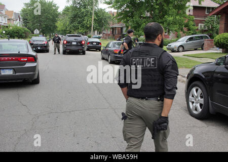 Service de police de Detroit, officier des opérations spéciales tiroirs son arme alors qu'il se prépare à aborder une maison, qu'ils en ont l'air d'un suspect, Detroit, Michigan, USA Banque D'Images