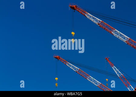 Résumé image du chantier de construction des grues à tour de flèche peintes en rouge et blanc pour la sécurité à Tokyo, Japon. Banque D'Images