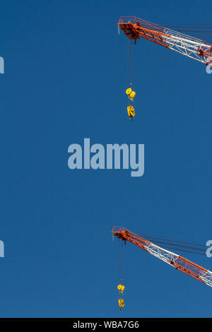 Résumé image du chantier de construction des grues à tour de flèche peintes en rouge et blanc pour la sécurité à Tokyo, Japon. Banque D'Images