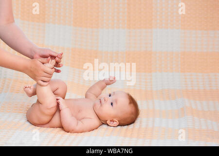 Massage pour bébé. Massage du ventre de la mère enfant, bébé rire. Traitement des coliques. Mère masser son enfant. Famille, nouveau-né. Famille heureuse. Les soins du corps. Banque D'Images