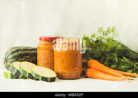 La mise en conserve des légumes fermentés conservés divers courgettes carottes en pots sur une table un fond clair. Traitement de l'automne culture d'été. Fo en conserve Banque D'Images