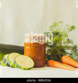 La mise en conserve des légumes fermentés conservés divers courgettes carottes dans des bocaux en verre sur une table un fond clair. Traitement de l'automne culture d'été. Pouvez Banque D'Images