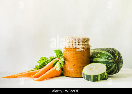 La mise en conserve des légumes fermentés conservés divers courgettes carottes en pots sur une table un fond clair. Traitement de l'automne culture d'été. Fo en conserve Banque D'Images
