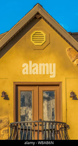 Close up vertical de la moitié d'un balcon circulaire accueil avec double porte et mur brun Banque D'Images