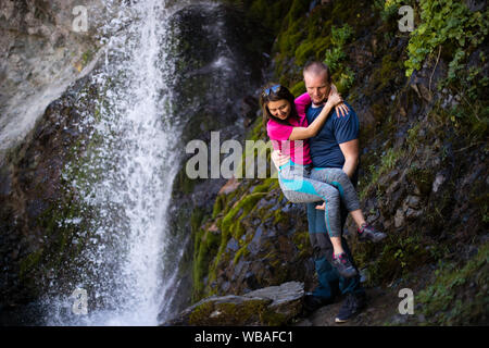 Un couple se pose à côté d'une cascade populaire dans la vallée d'Alameddin, dans l'oblast de Chuy au Kirghizistan. Banque D'Images