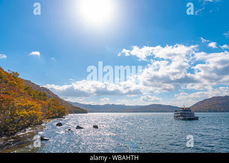 Lac Towada croisières touristiques. Belle vue, ciel bleu clair, nuage blanc, navire de croisière en journée ensoleillée avec la saison des feuilles d'automne arrière-plan. Aomori Banque D'Images