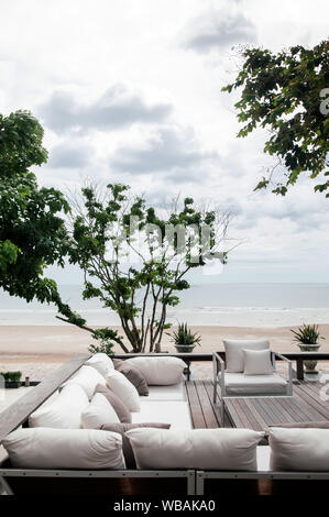 AUG 7 2014, Hua Hin, Thaïlande - vacances tropicales. seaview balcon en bois avec tissu blanc canapé lit et oreillers sous l'arbre vert luxuriant et tropical Banque D'Images