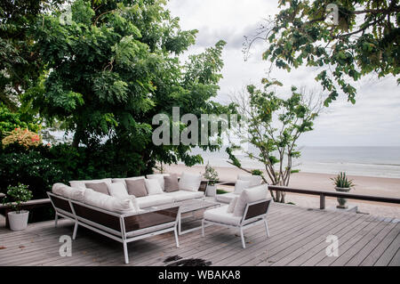 AUG 7 2014, Hua Hin, Thaïlande - vacances tropicales. seaview balcon en bois avec tissu blanc canapé lit et oreillers sous l'arbre vert luxuriant et tropical Banque D'Images