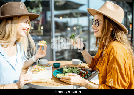 Les deux meilleurs amis de manger des aliments sains tout en étant assis sur une terrasse de restaurant un jour d'été Banque D'Images