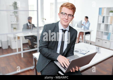Smiling Red Haired Woman Holding Laptop Banque D'Images