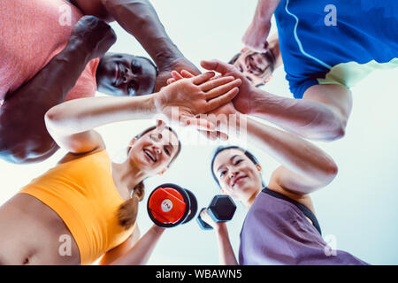 Quatre amis dans la salle de sport s'amuser Banque D'Images