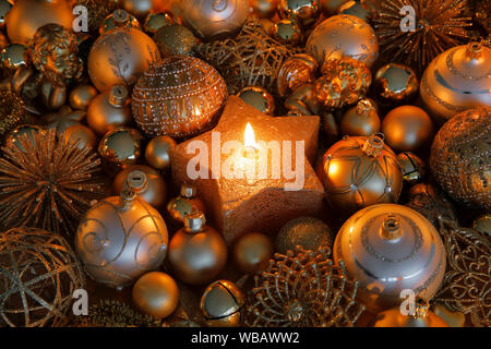 Boules de Noël d'or et la gravure tealight dans un bougeoir en forme d'étoile. Studio photo. La Suisse Banque D'Images