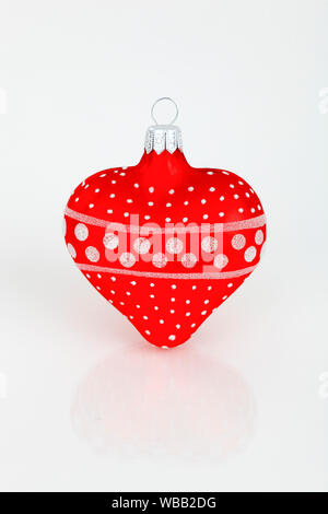 Forme de coeur Boule de Noël en rouge et blanc. Studio photo sur un fond blanc. La Suisse Banque D'Images