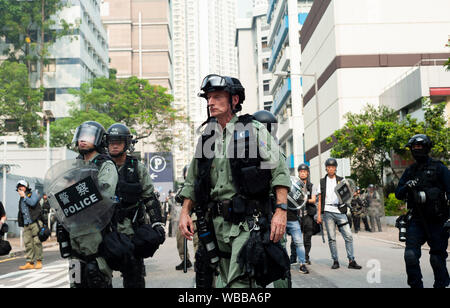 Hong Kong, Chine. Août 24, 2019. La police anti-émeute se rassemblent en formation en vue d'exiger une grande masse de manifestants pro-démocratie sur la route à Kwun Tong. Des manifestants pro-démocratie et de la police en tenue de combat s'affrontent dans Kwon Tong tout au long de la journée. La police a utilisé des balles en caoutchouc, pepper ball des fusils et des gaz lacrymogènes pour réprimer la grande foule de manifestants qui ont érigé des barricades et jeté des pierres et des cocktails molotov.Les manifestations de masse continue pendant encore un week-end à Hong Kong qui a commencé en juin 2019 sur un projet de loi sur l'extradition suspendue-maintenant à la Chine. Credit : SOPA/Alamy Images Limited Live News Banque D'Images