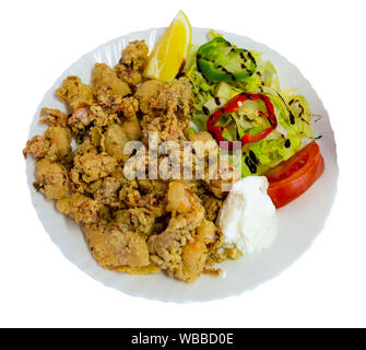 Plat de fruits de mer espagnol chipirones a la andaluza, enrobés de calmars servis avec salade de légumes frais. Plus isolé sur fond blanc Banque D'Images