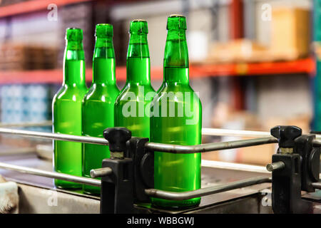 Les bouteilles de cidre de pomme verte avec sur ligne d'embouteillage en asturien traditionnel Sidreria Banque D'Images