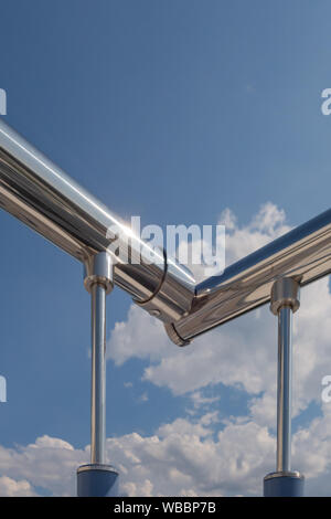 Escaliers garde-corps en acier inoxydable de l'extérieur de l'édifice, sur un fond de ciel bleu et de beaux nuages. Des tuyaux, des charnières, des balustres faites de sta Banque D'Images
