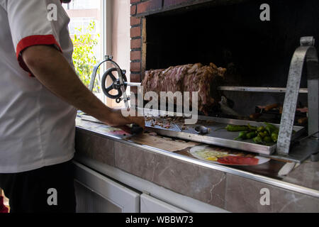 Chef prépare un bain turc traditionnel cag kebab dans un restaurant à Istanbul.Cag kebab est ressemble à döner kebab,mais c'est mettre le feu avant horiz Banque D'Images