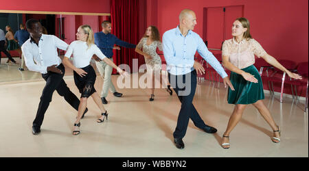 Les jeunes gens sourire active la pratique de mouvements de danse lindy hop en classe Banque D'Images