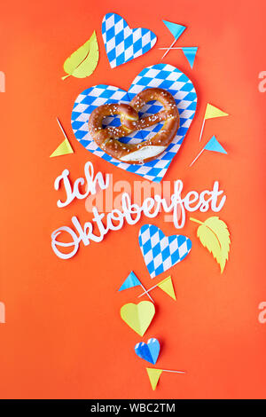 Texte papier 'J'aime' Oktoberfest en allemand, mise à plat sur le papier de fond avec bretzel sur plaques de papier décoratif, coeurs, drapeaux et les feuilles d'automne. Banque D'Images