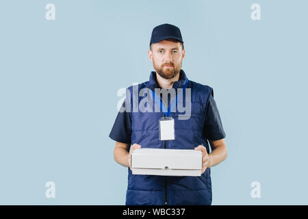 Delivery man en uniforme est Holding boîte en carton blanc Banque D'Images