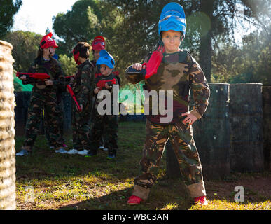 Preteen boy en uniforme et la tenue de fusil prêt pour jouer avec des amis en plein air paintball Banque D'Images