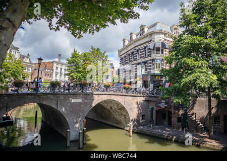 Utrecht, Pays-Bas - 01 juillet 2019 - pont de pierre au-dessus de fleuve avec des vélos et méconnaissable personnes près de beaux bâtiments dans la vieille ville Banque D'Images