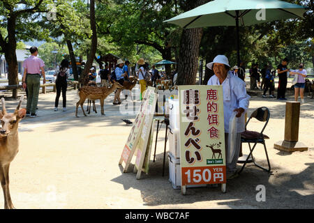 Les vendeurs de rue vendre deer craquelins pour touristes pour eux de nourrir au sacré deer de Nara, au Japon. Banque D'Images