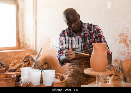 African American male Professionnel peinture potter dans un pot en céramique atelier de poterie Banque D'Images