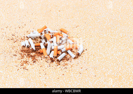 Cigarettes Pile cassée sur fond jaune table parquet mosaïque. soins de santé concept arrêter de fumer. Banque D'Images