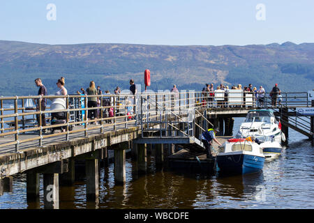 Luss, ARGYLL & BUTE, Ecosse, août, 25, 2019 : Des centaines de personnes se rendent dans un petit village pittoresque sur la rive ouest du Loch Lomond pour bronzer et Banque D'Images