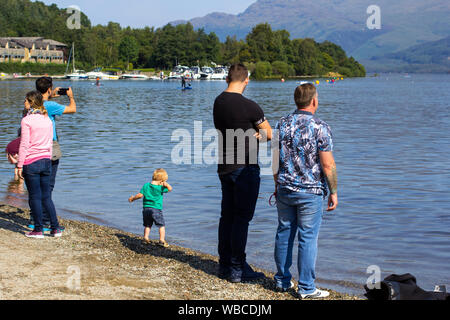 Luss, ARGYLL & BUTE, Ecosse, août, 25, 2019 : Des centaines de personnes se rendent dans un petit village pittoresque sur la rive ouest du Loch Lomond pour bronzer et Banque D'Images