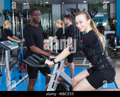 Jeune femme sportive de plein-corps d'une stimulation musculaire électrique formation dans un club de santé Banque D'Images