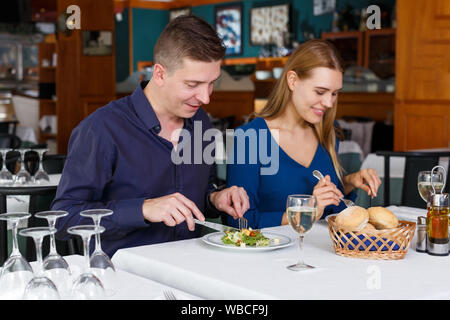Couple heureux sur la salade et de l'alimentation date drinking white wine in restaurant Banque D'Images