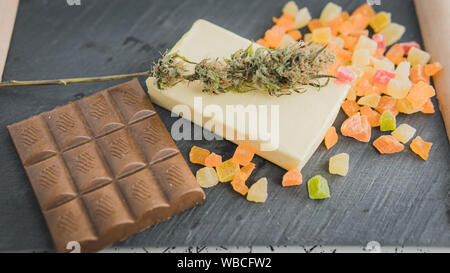 La préparation à la cuisson gâteau avec le beurre de cannabis. Concept de l'utilisation de la marijuana dans l'industrie alimentaire. Gâteau avec la CDB et les bourgeons de cannabis de la marijuana sur la table Banque D'Images