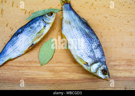 Le poisson séché Roach sur une planche à découper en bois. Aliments et boissons. Banque D'Images