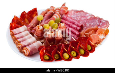 Tranches de salés à sec espagnol gammon, variété de saucisses et bacon servi avec des olives sur plaque ronde. Plus isolé sur fond blanc Banque D'Images